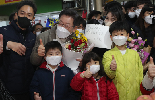 이재명 민주당 대선후보와 부인 김혜경 씨가 지난 12일 경북 김천시 김천 황금시장에서 어린이들과 기념촬영하고 있다. 연합뉴스